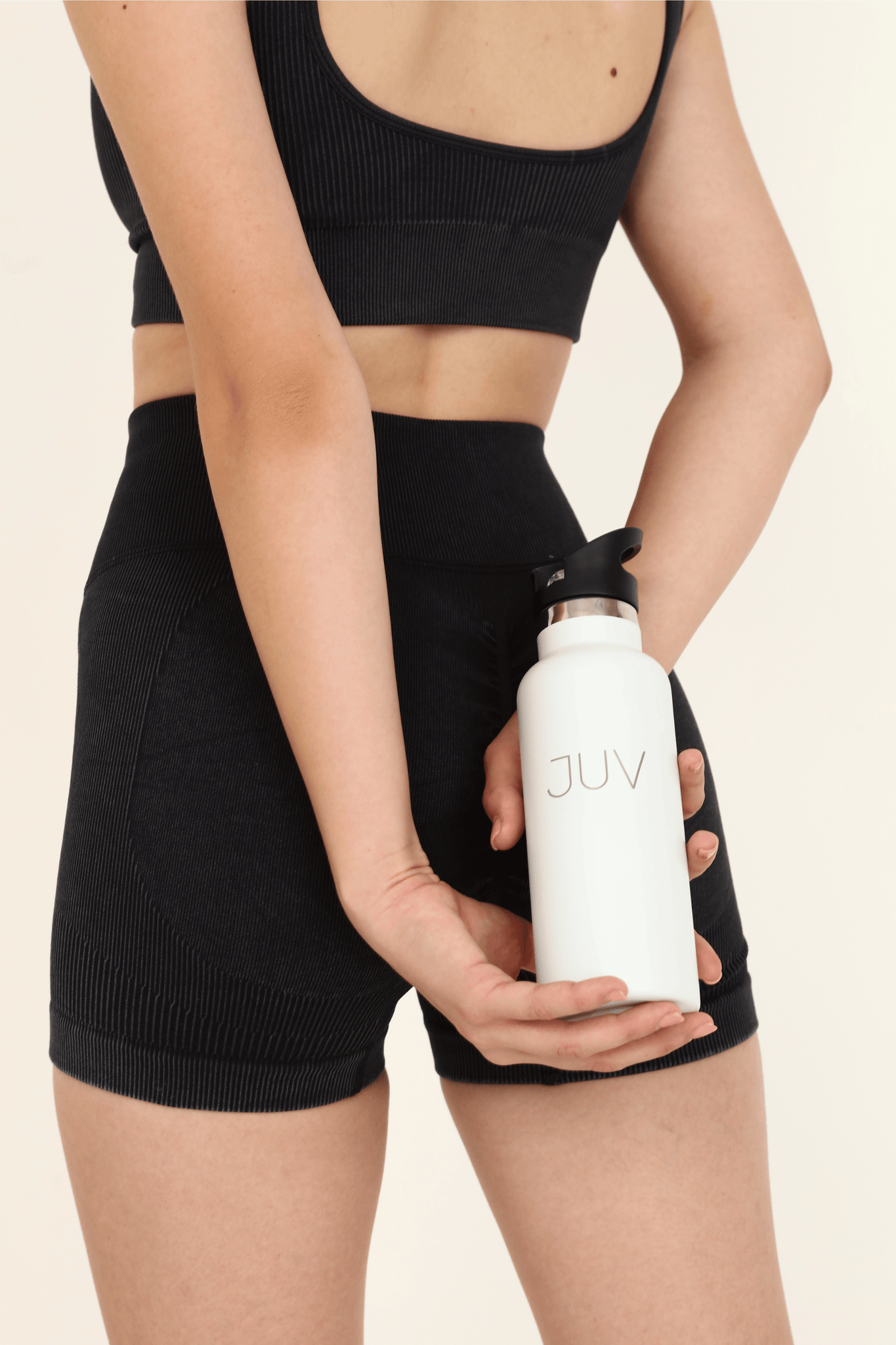 JUV pure thermal bottle with sipper in white, front view in model hands. 