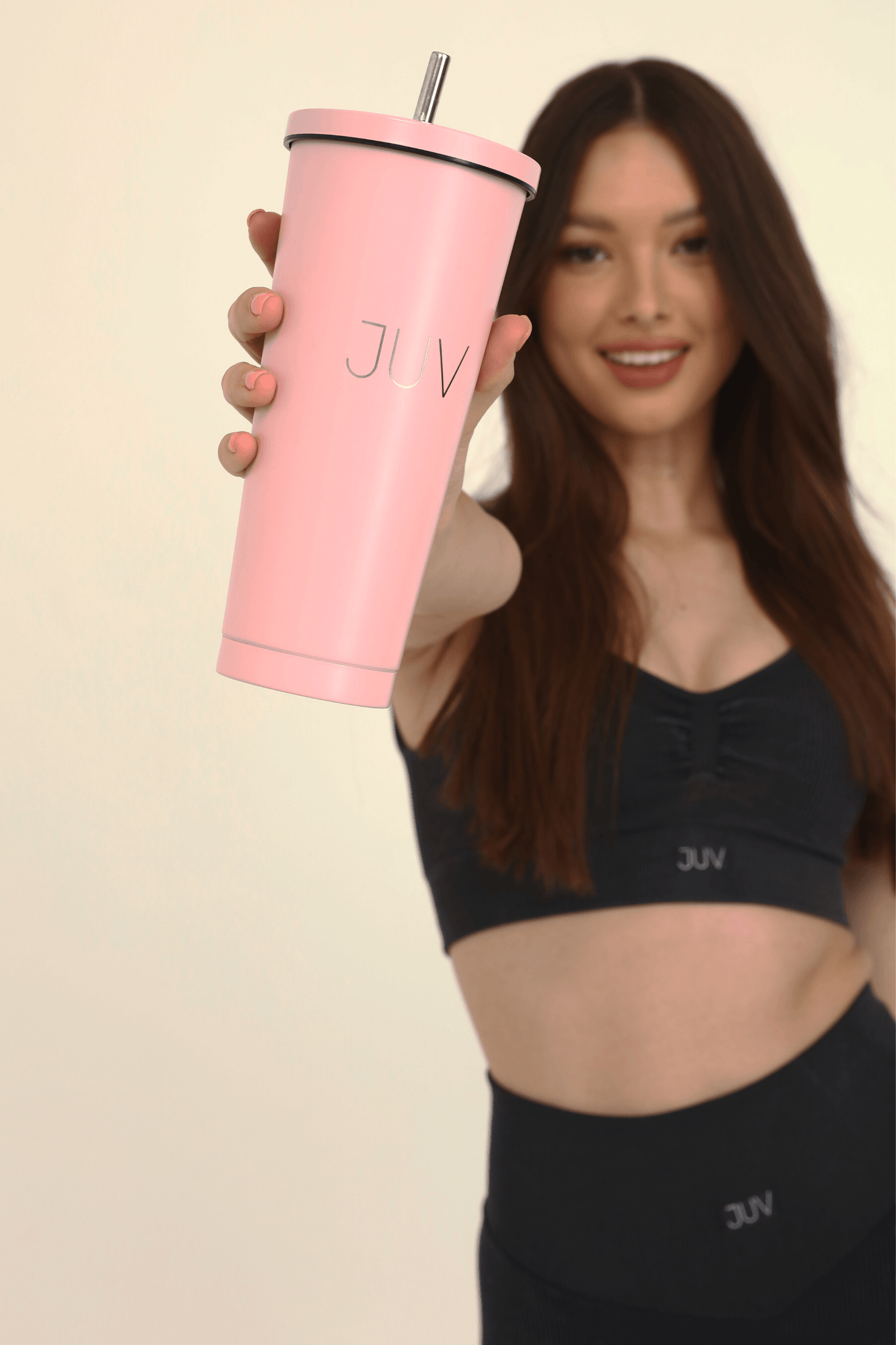 JUV lady thermal cup in pink, side/front view in model hands.