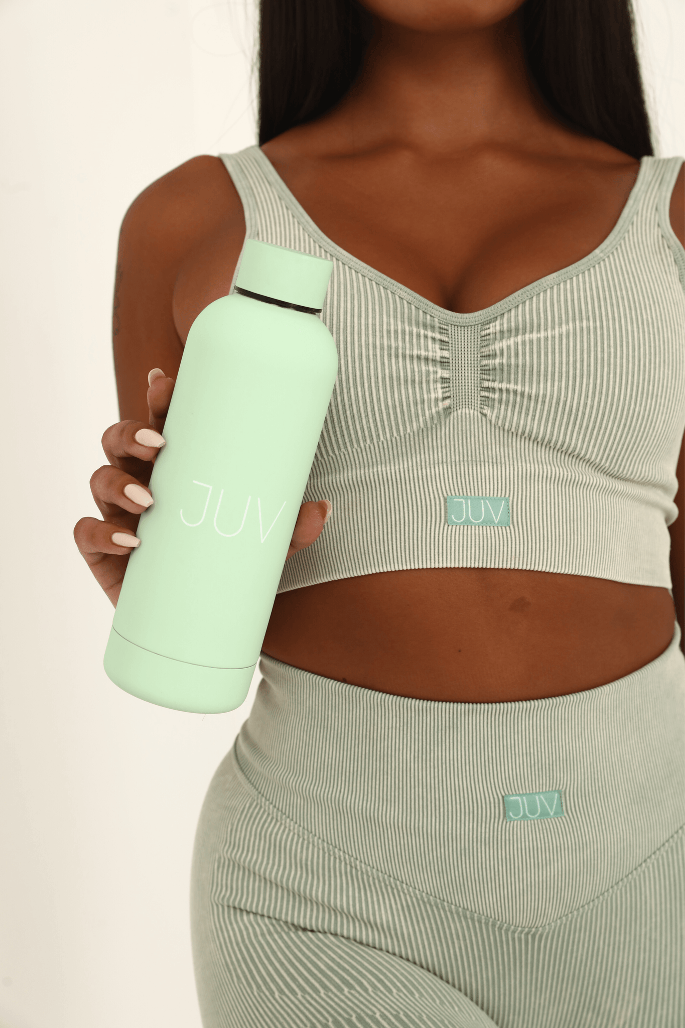 JUV mia thermal bottle in mint green, close up front view in the model hands.