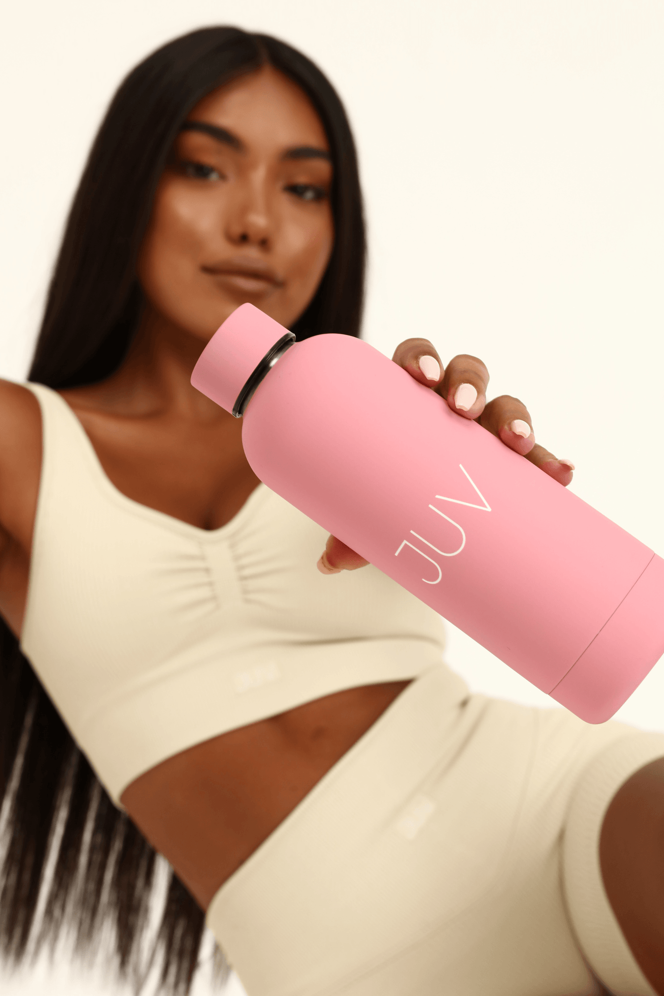 JUV mia thermal bottle in pink, front view in the model hands.