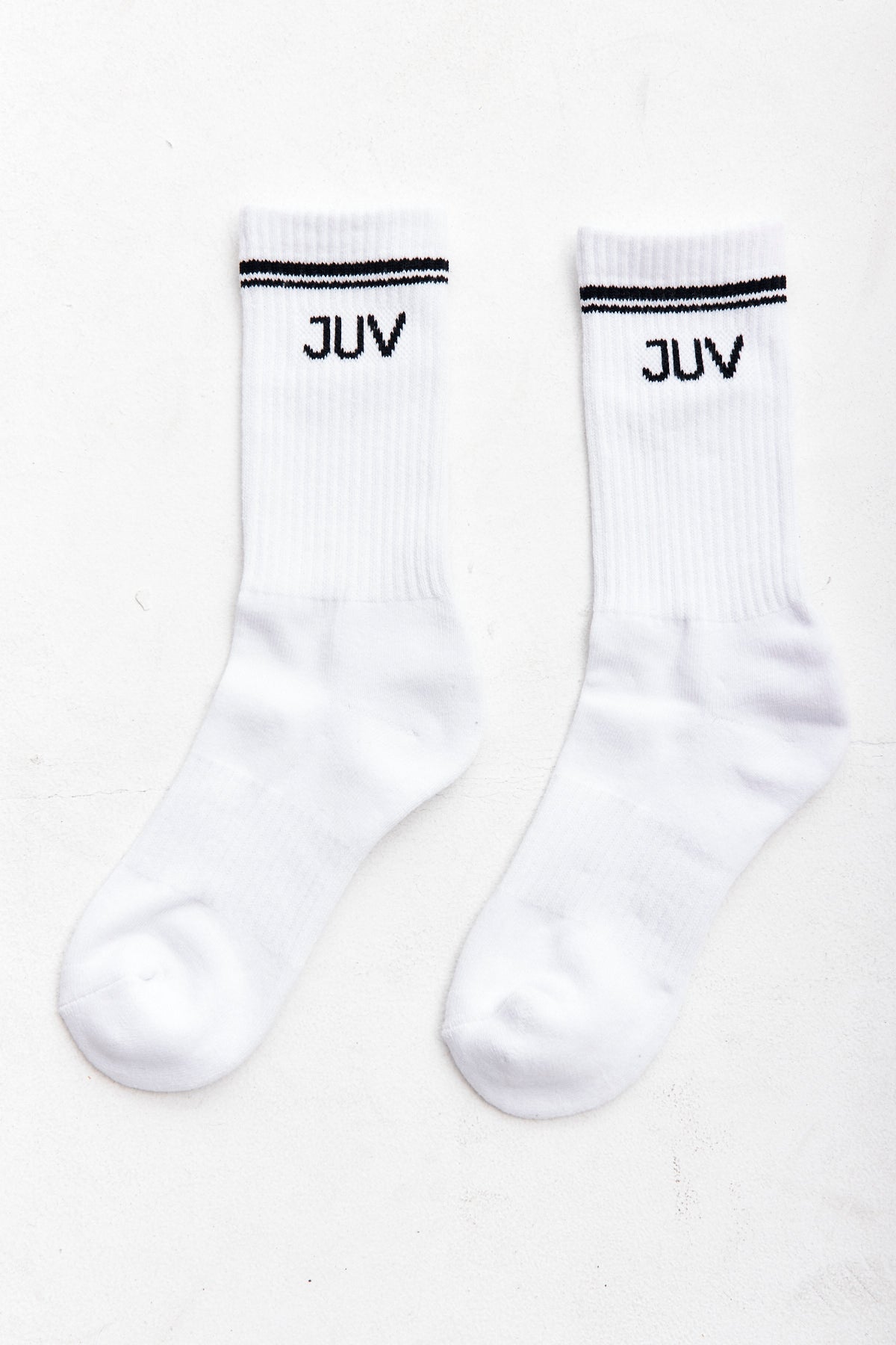 JUV crew socks in white, close up view of the socks in a white background.